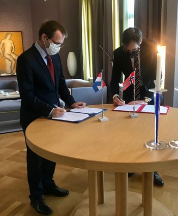 Ondertekening van de overeenkomst in Nederland door Harm van de Wetering, directeur NSO (rechts), en Bård Ivar Svendsen, de Noorse ambassadeur.